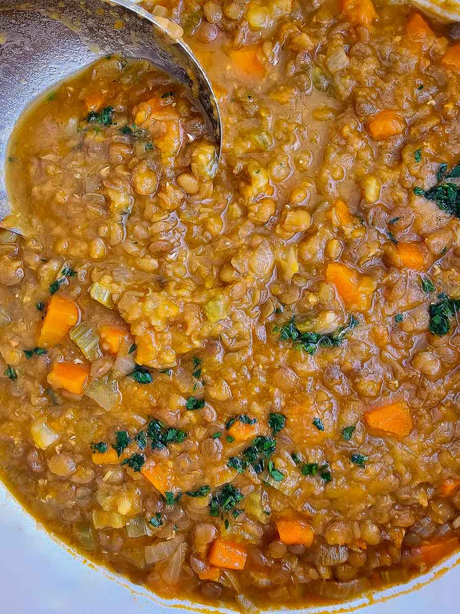 Greek lentil soup, fakes in pot with ladle.