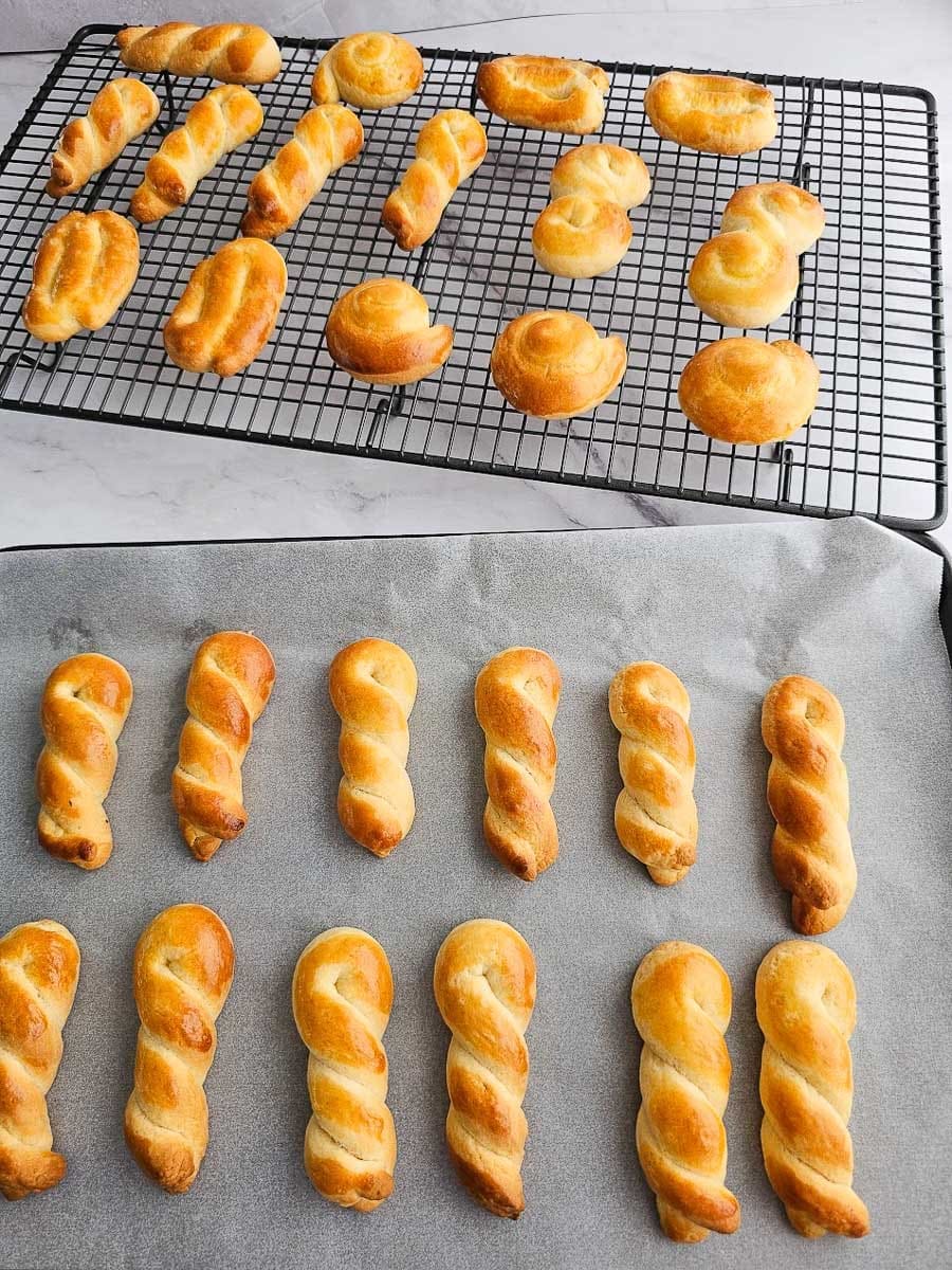 Greek Easter cookies-koulourakia, on baking tray and cooling rack.