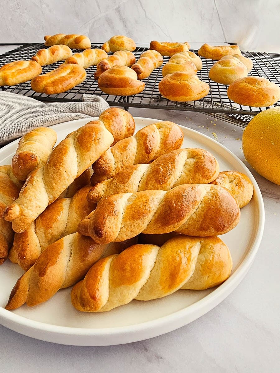 Greek Easter cookies-koulourakia on white plate and cooling rack.