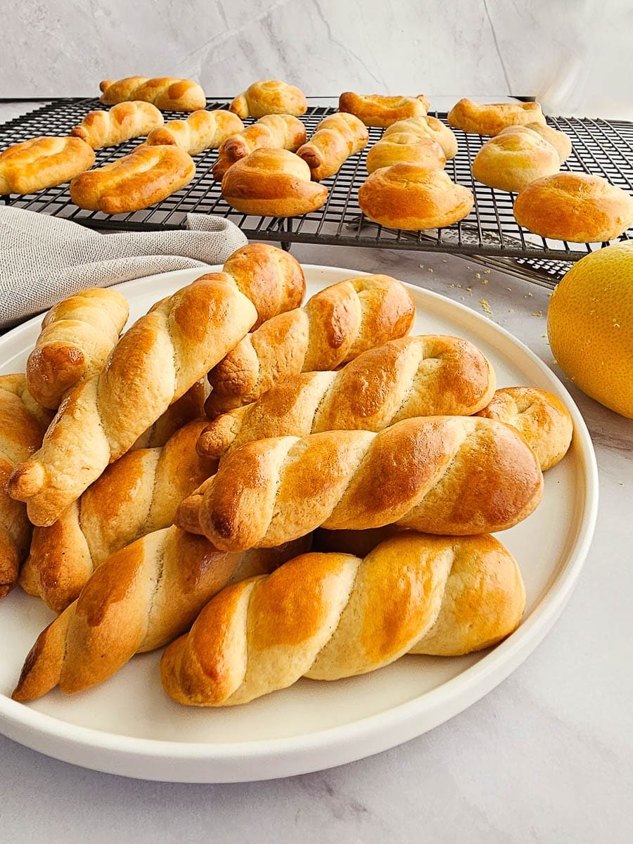 Greek Easter cookies-koulourakia on white plate and cooling rack in background