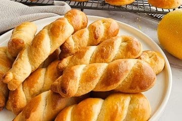 Greek Easter cookies-koulourakia on white plate and cooling rack.