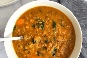 Greek lentil soup, fakes in a bowl with a spoon.