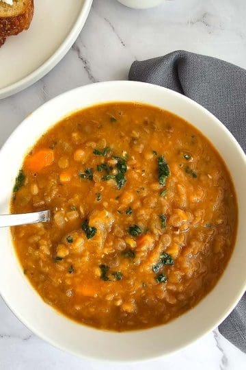 Greek lentil soup, fakes in a bowl with a spoon.