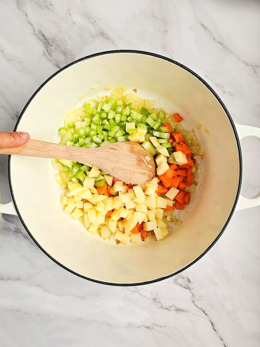 Greek lentil soup-fakes-saute onions and vegetables in pot. 