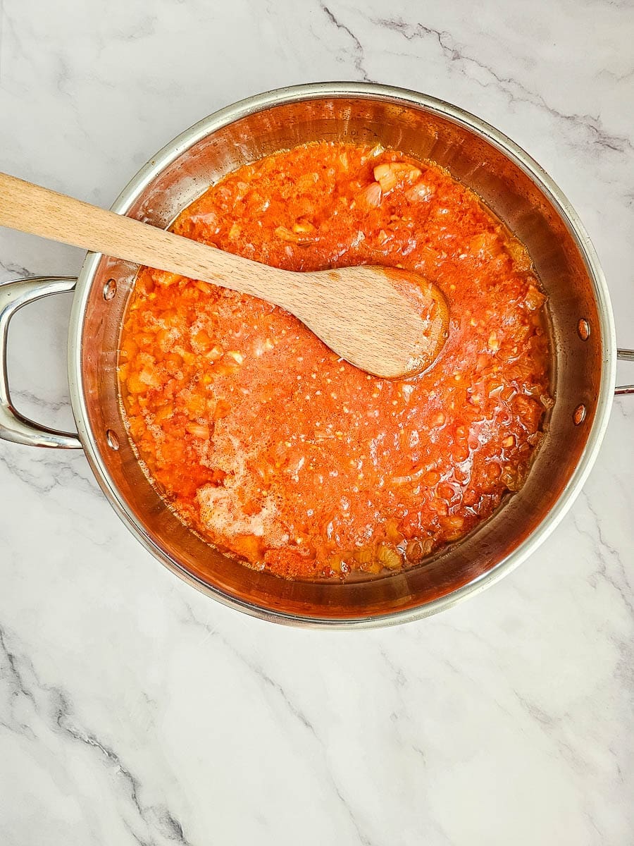 Yemista, stuffed tomatoes with rice, saute onions and tomato in pan. 