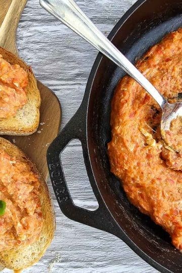 strapadsada-scrambled eggs and tomatoes in pan and on sliced bread on board