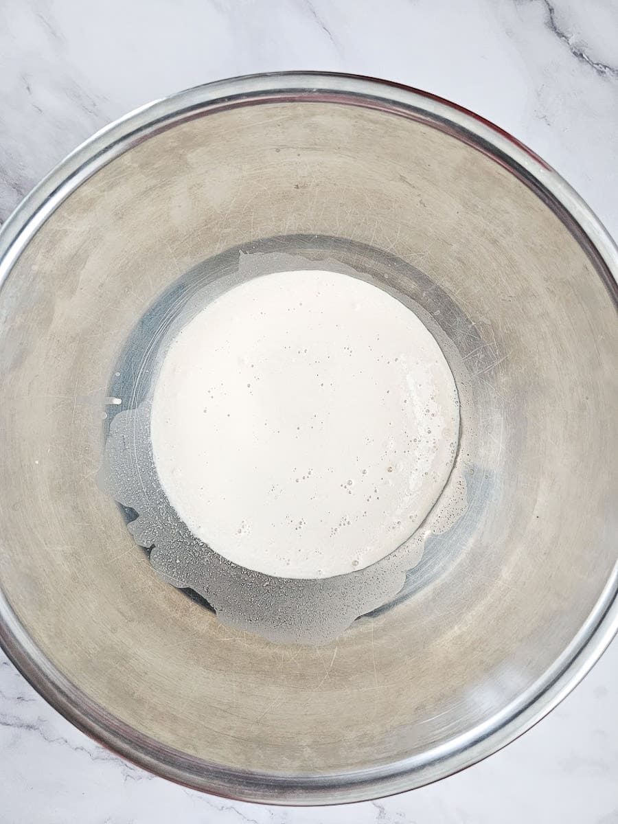 tsoureki-yeast, sugar and milk in a bowl