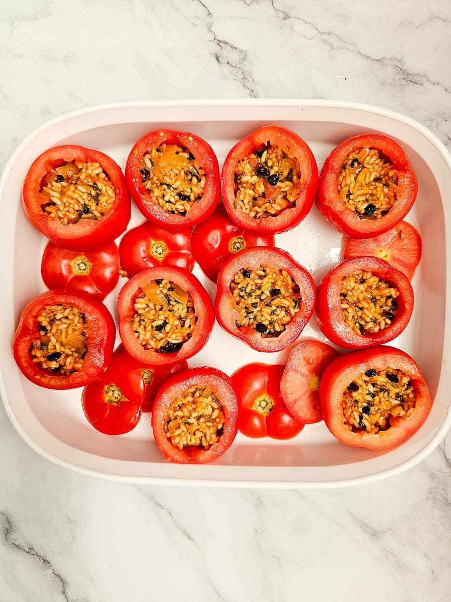 Yemista, stuffed tomatoes with rice, filled with rice filling in baking dish.