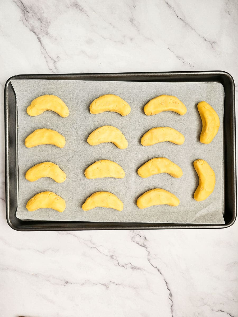 Greek Almond Shortbread Cookies-Kourambiedes-on baking tray before baking-crescent shapes