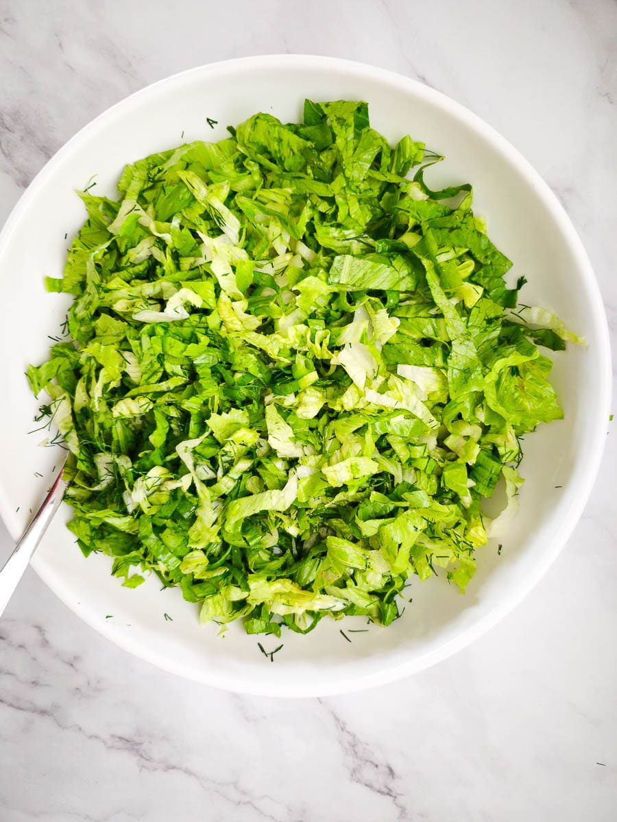 Greek lettuce salad - maroulosalata - mixing ingredients