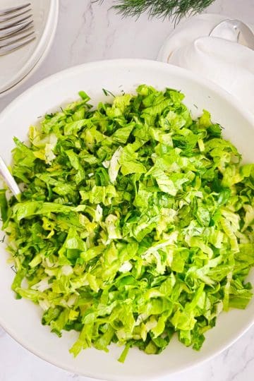 Greek lettuce salad maroulosalata in a white bowl