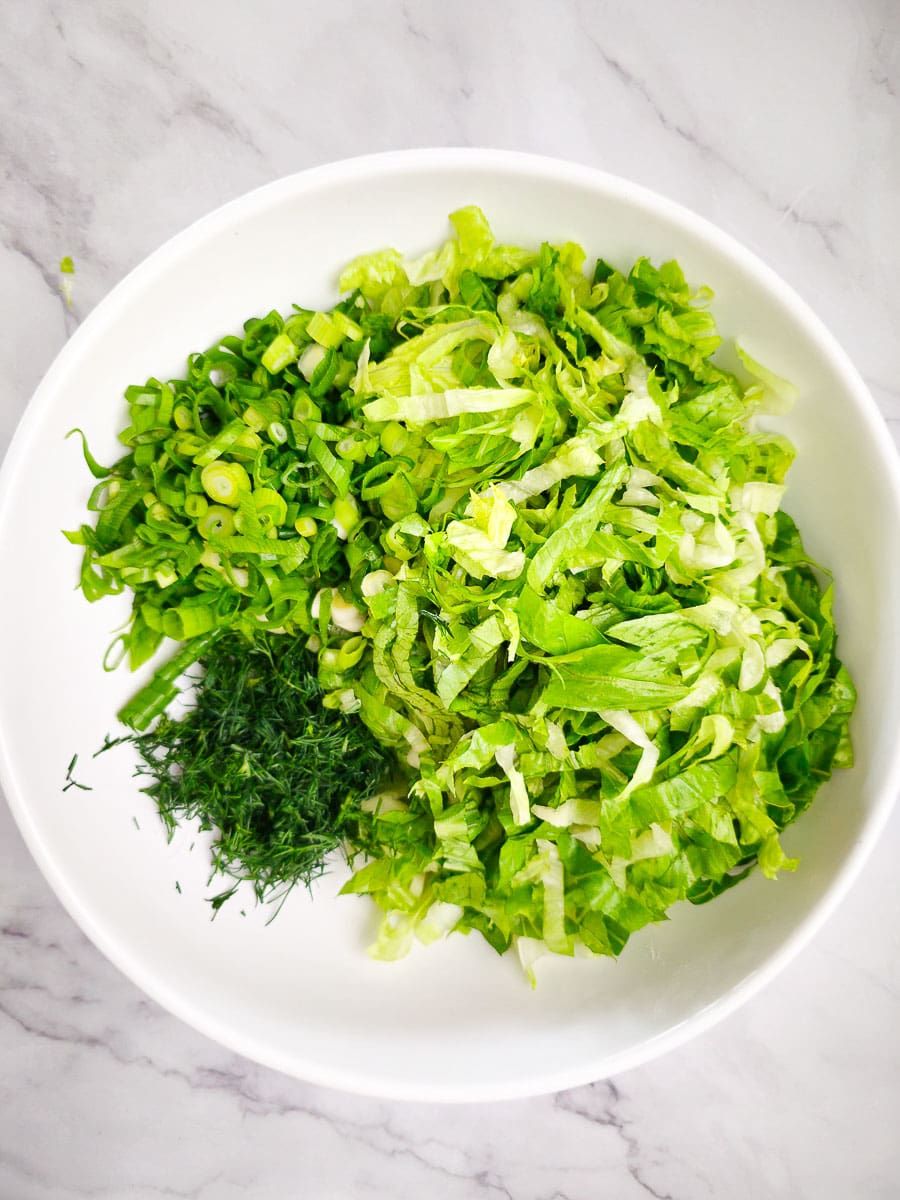 Greek lettuce salad - maroulosalata - combining ingredients