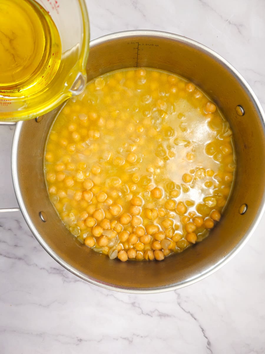 chickpea soup adding olive oil to pot