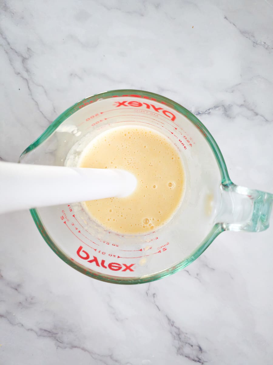 measuring jug with stick blender blending flour water paste