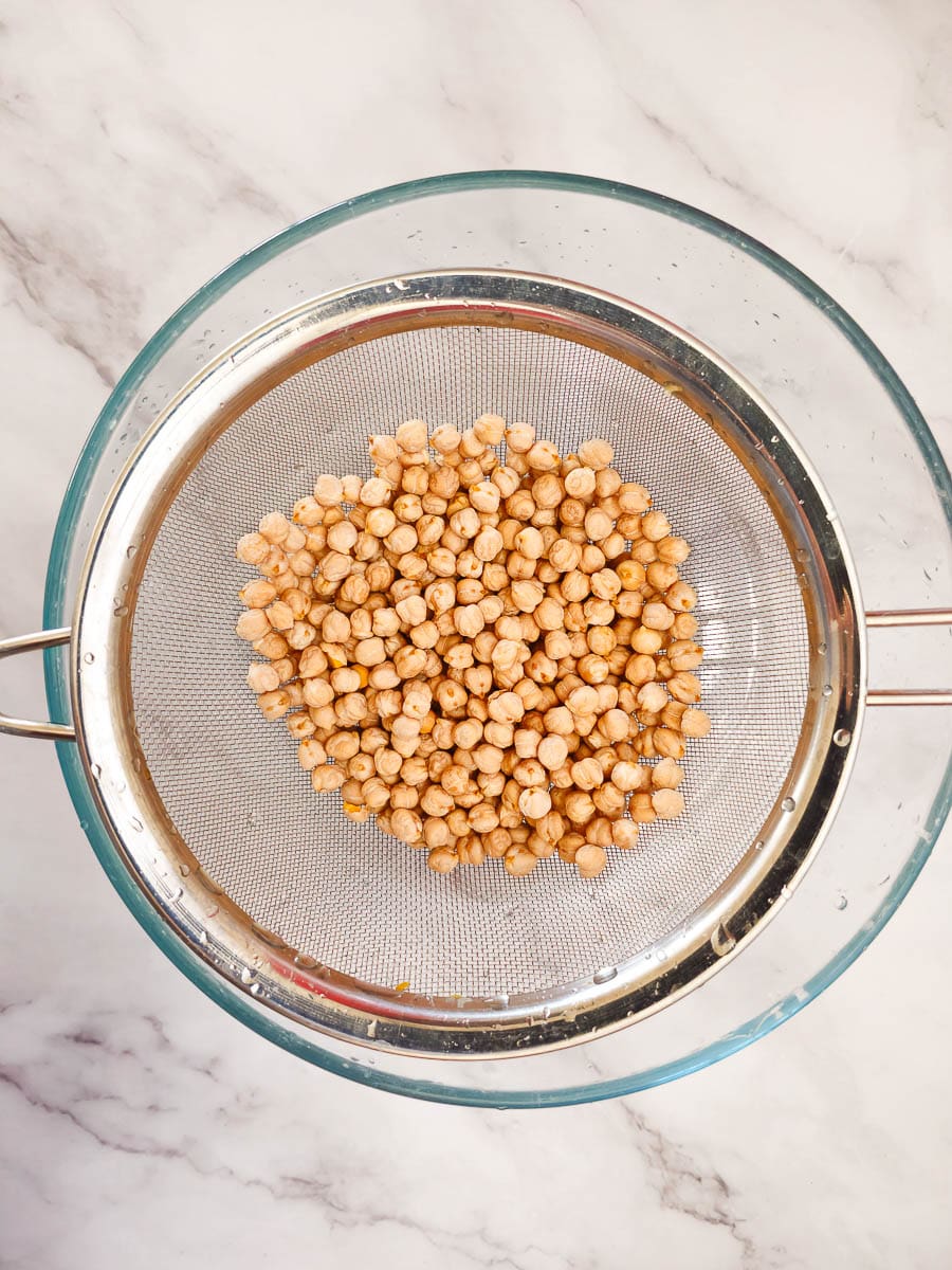 washing chickpeas with strainier in bowl