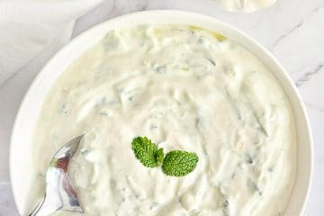 Tzatziki in white bowl with a spoon