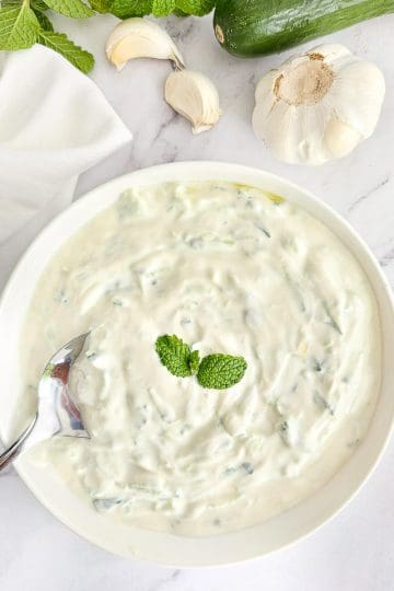 Tzatziki in white bowl with a spoon