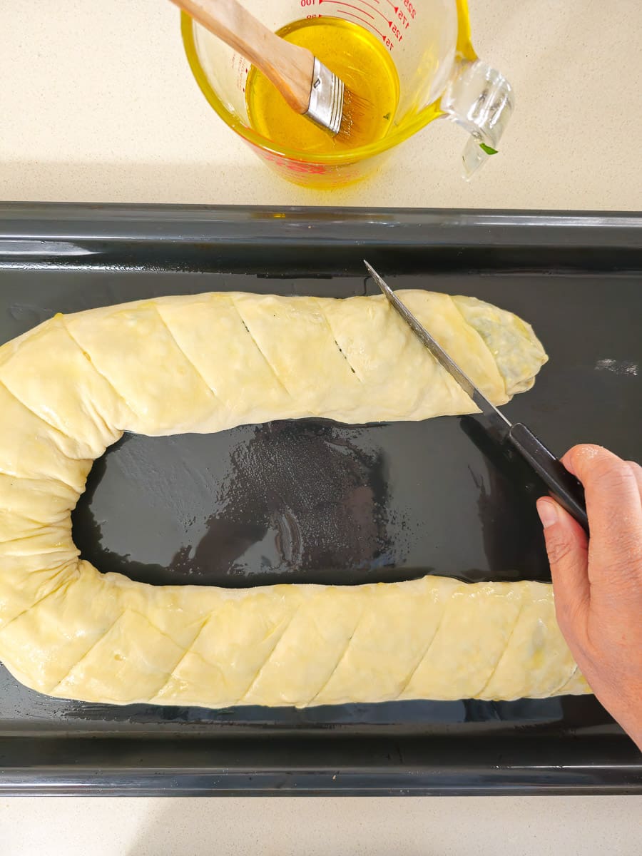 scoring spanakopita on baking tray