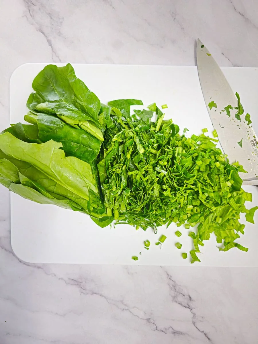 chopping English spinach on chopping board