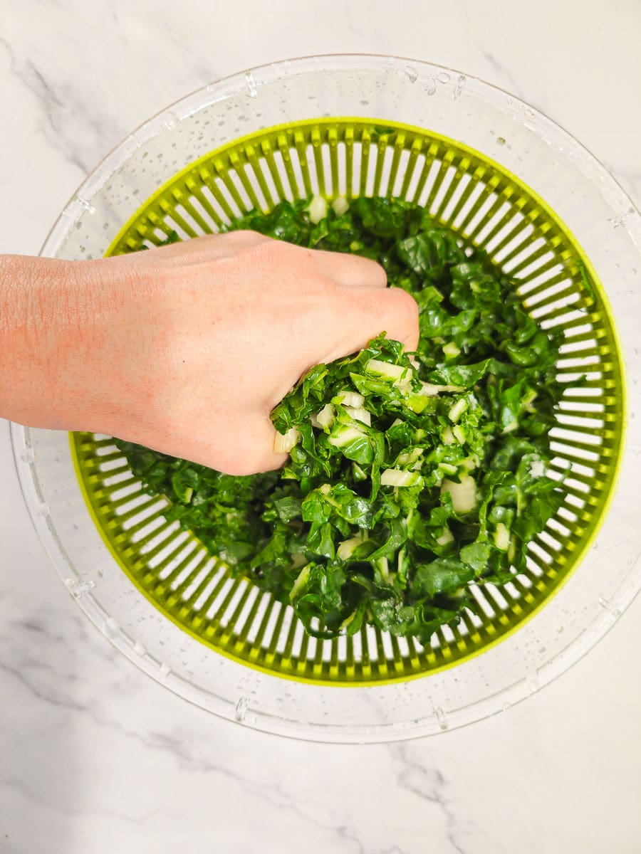 squeezing excess moisture from spinach for spanakopita