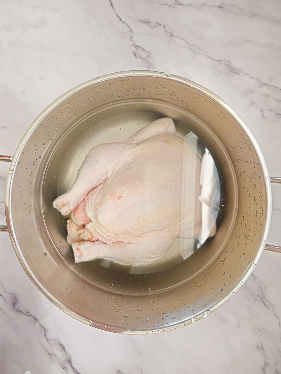 boiling a whole chicken in a saucepan