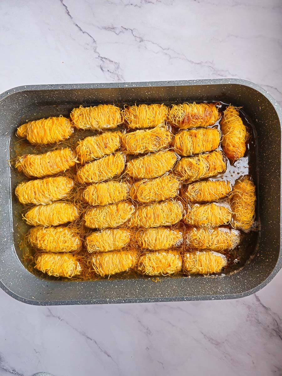 adding syrup to Rolling Kataifi - Greek String Pastry Nut Rolls 