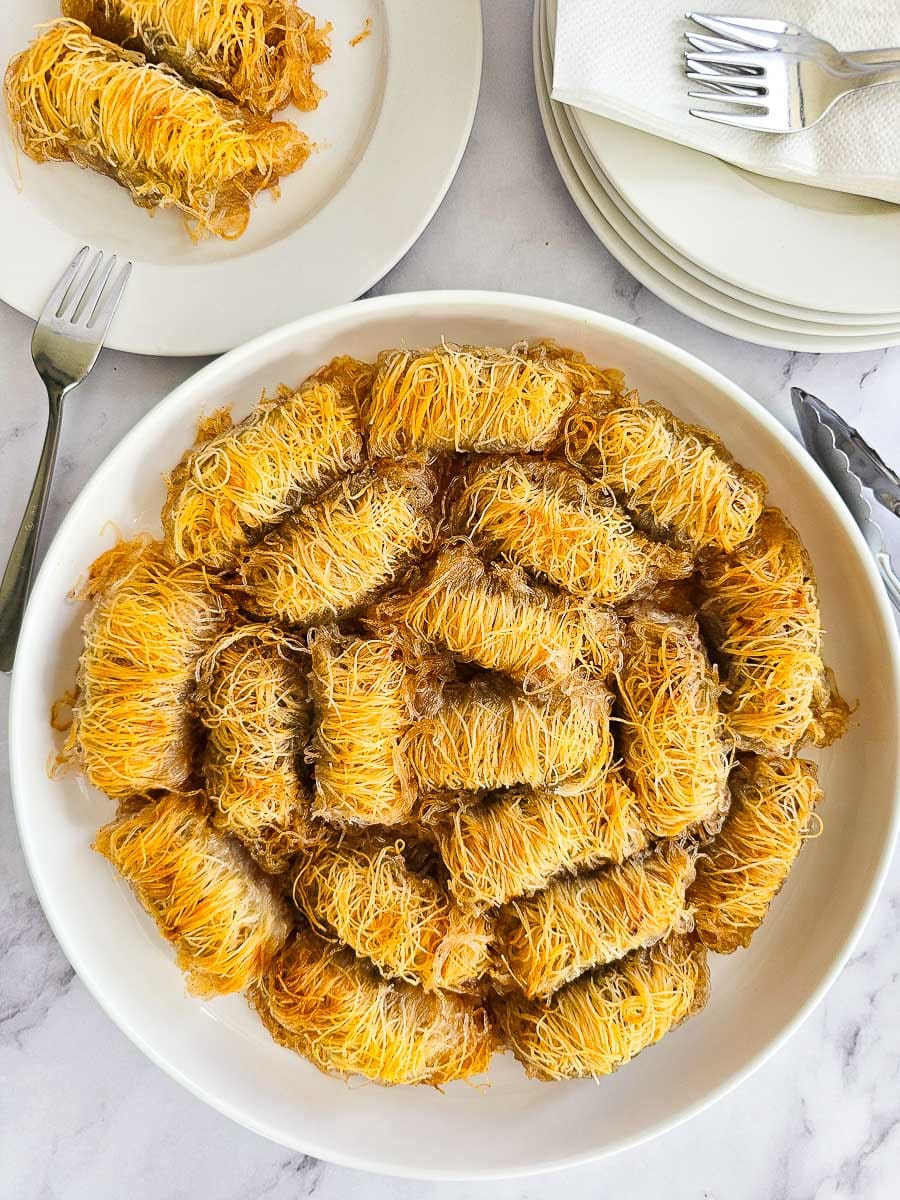 Rolling Kataifi - Greek String Pastry Nut Rolls on a plate ready to serve