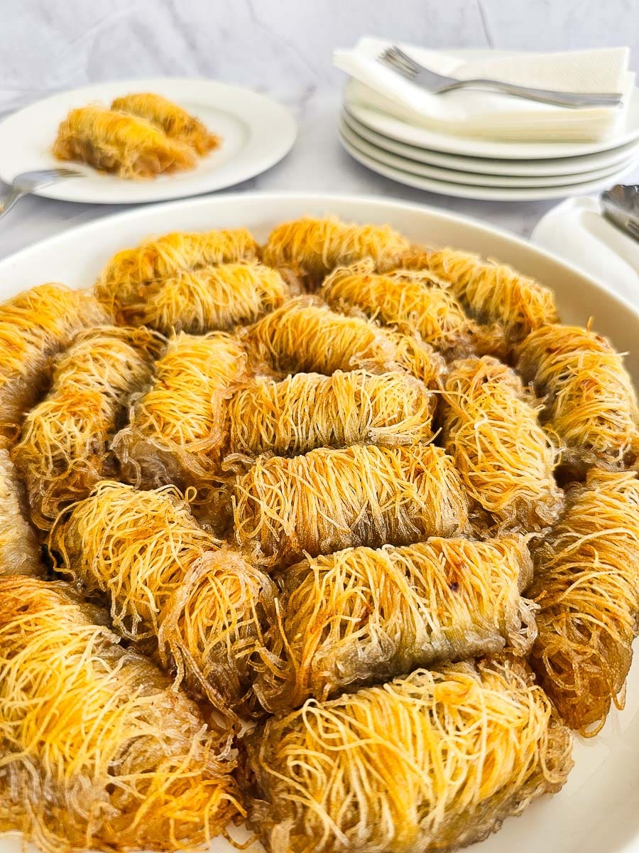 Rolling Kataifi - Greek String Pastry Nut Rolls on a plate ready to serve