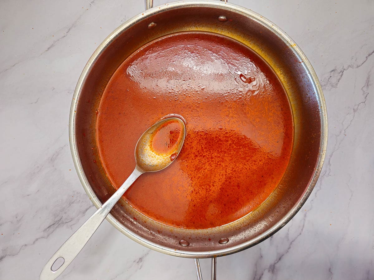 simmering tomato sauce (salsa) in a saucepan with a spoon