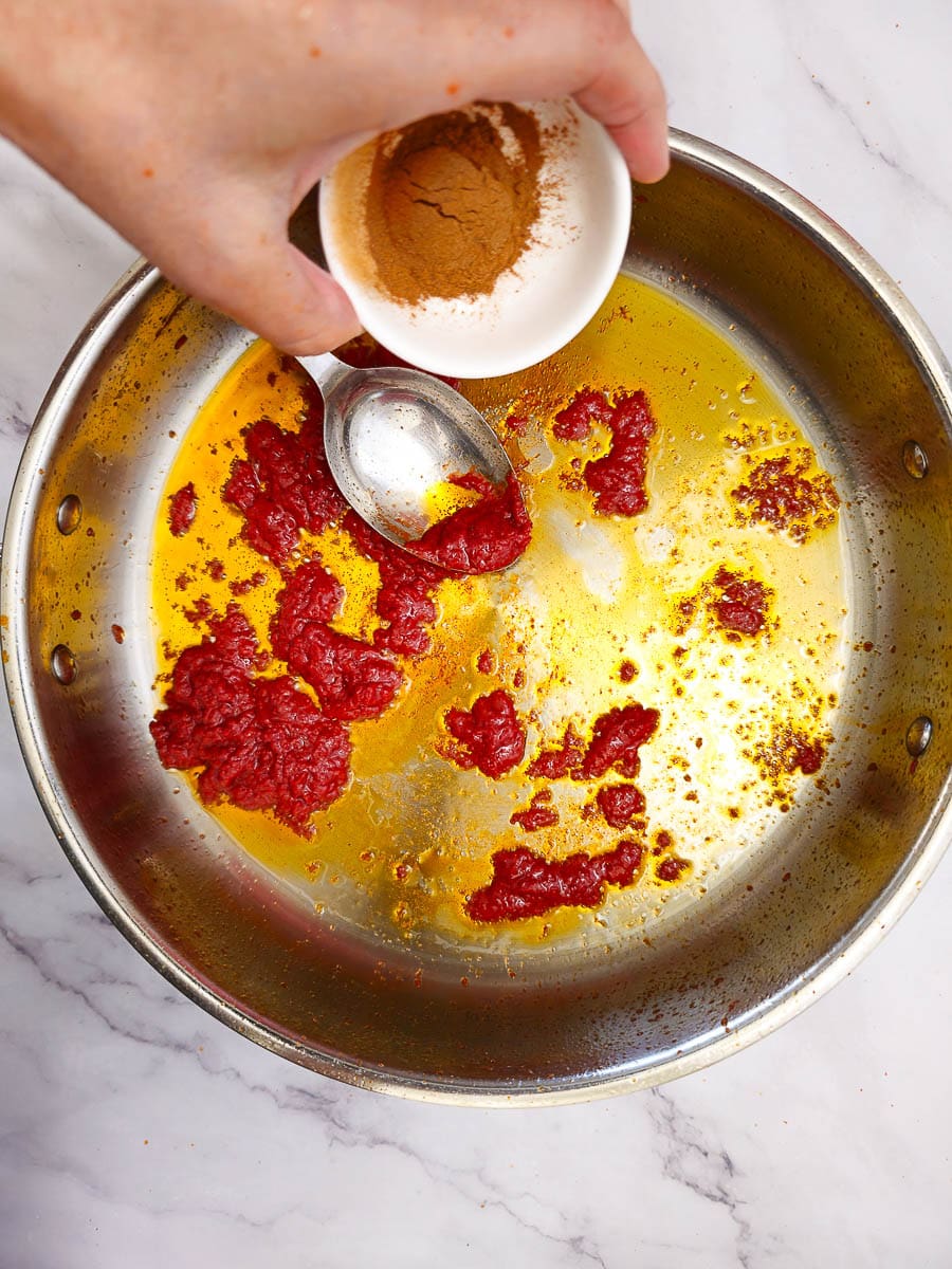 simmering tomato sauce (salsa) in a saucepan with a spoon