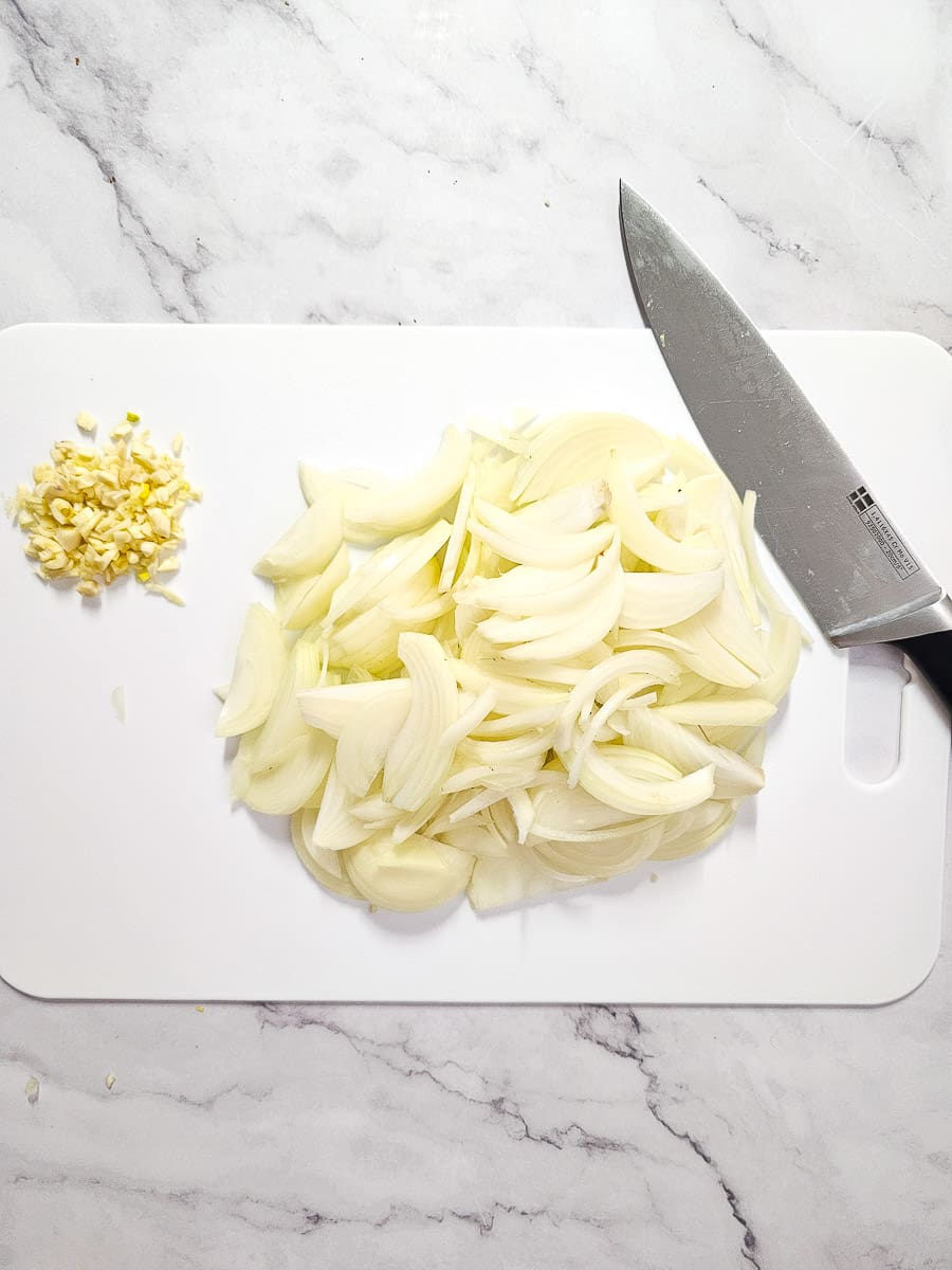 chopped onions and garlic on a chopping board