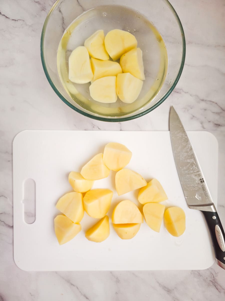 cutting potato into wedges on chopping board