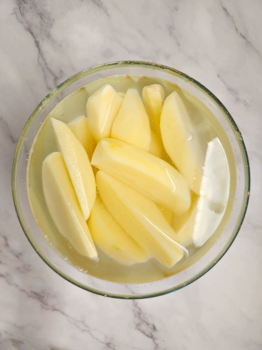 potato wedges in bowl of water