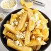 Greek Olive Oil Fries - Patates Tiganites, in a bowl with crumbled feta