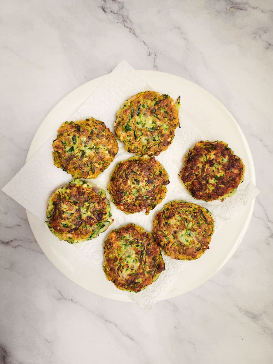 Greek zucchini fritters - kolokithokeftedes on a plate lined with paper towel