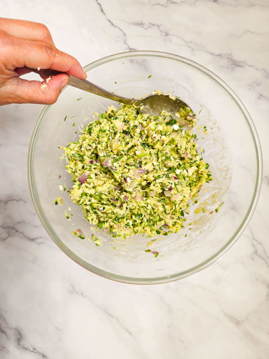 Greek zucchini fritters - kolokithokeftedes mixture in a bowl