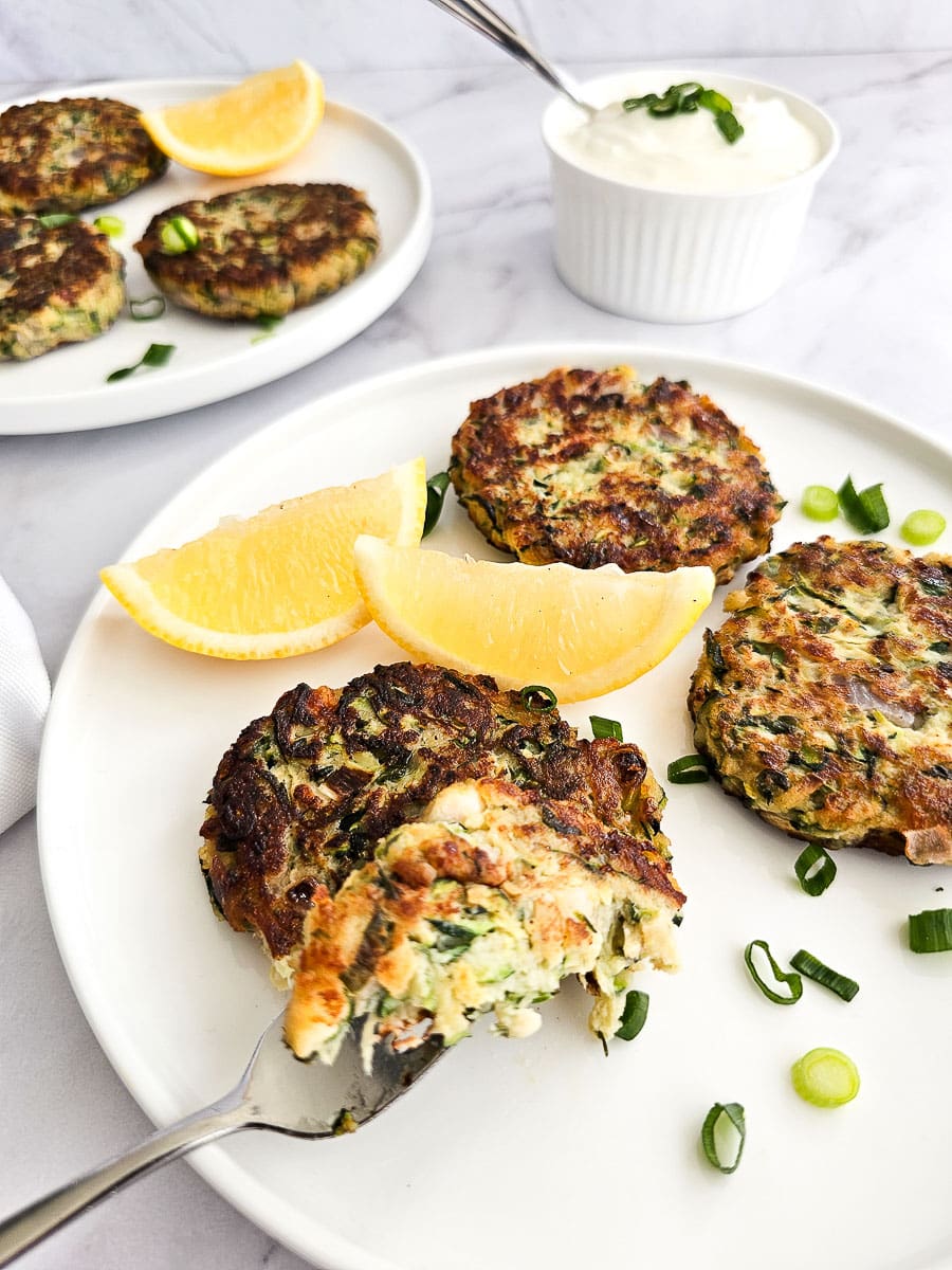 Greek Zucchini Fritters - Kolokithokeftedes on a plate with lemon