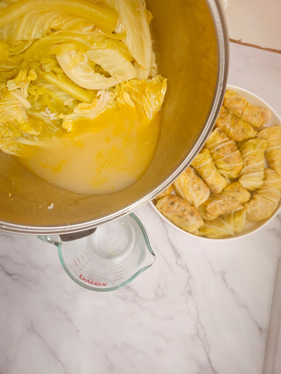 Lahanodolmades-Greek Stuffed Cabbage Rolls -measuring cooking liquid for sauce