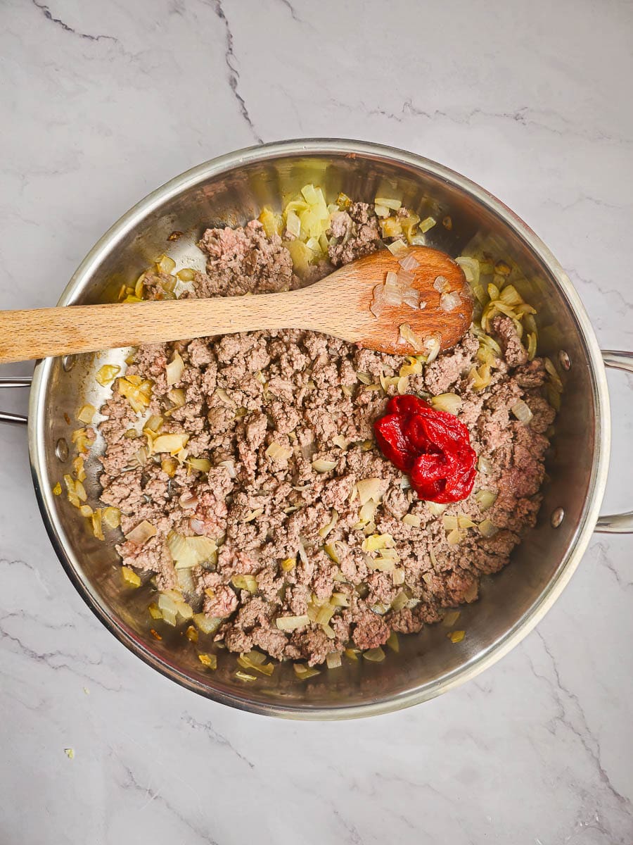 Lahanodolmades-Greek Stuffed Cabbage Rolls adding tomato paste to mince