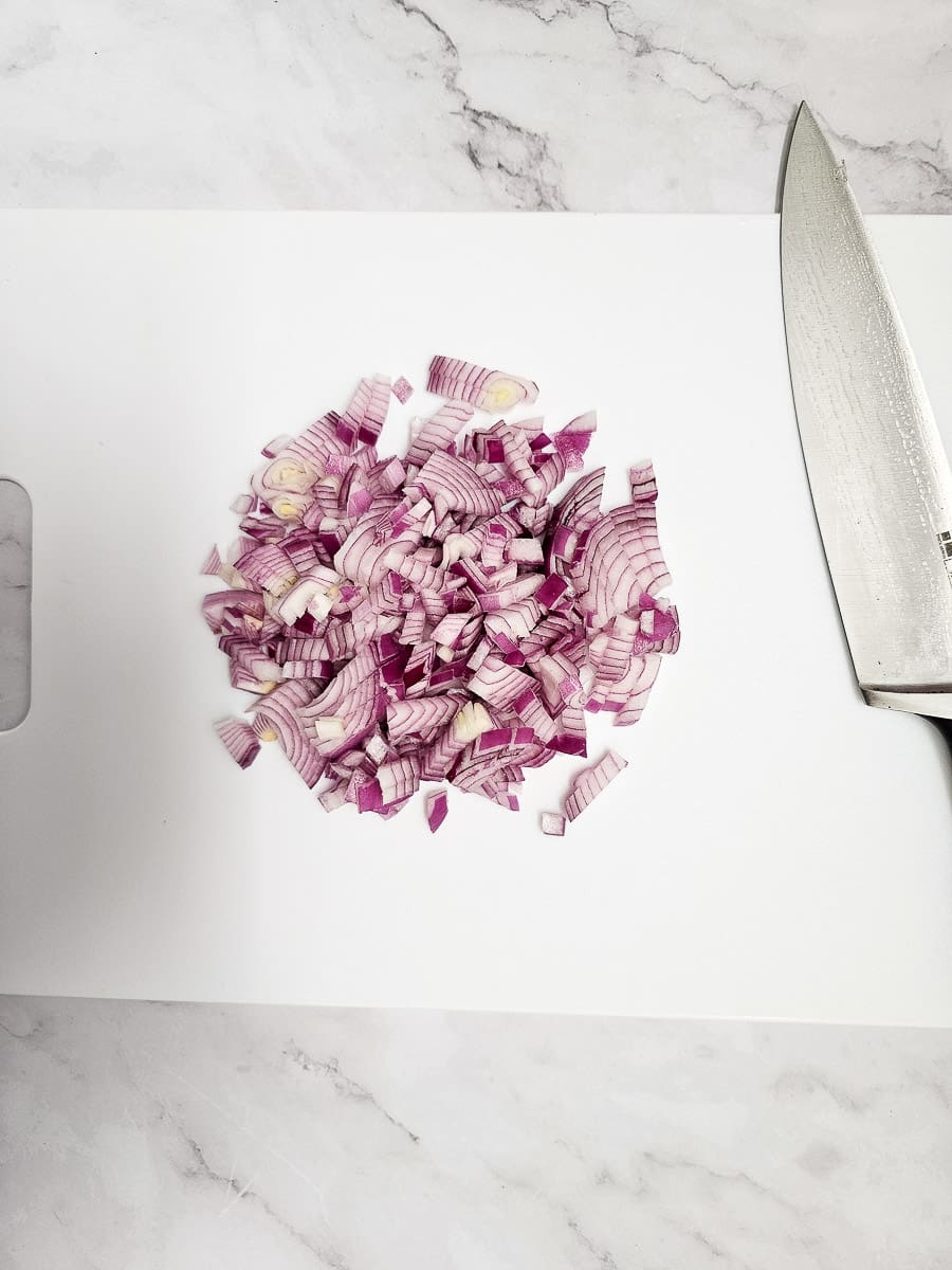 dicing red onion on chopping board