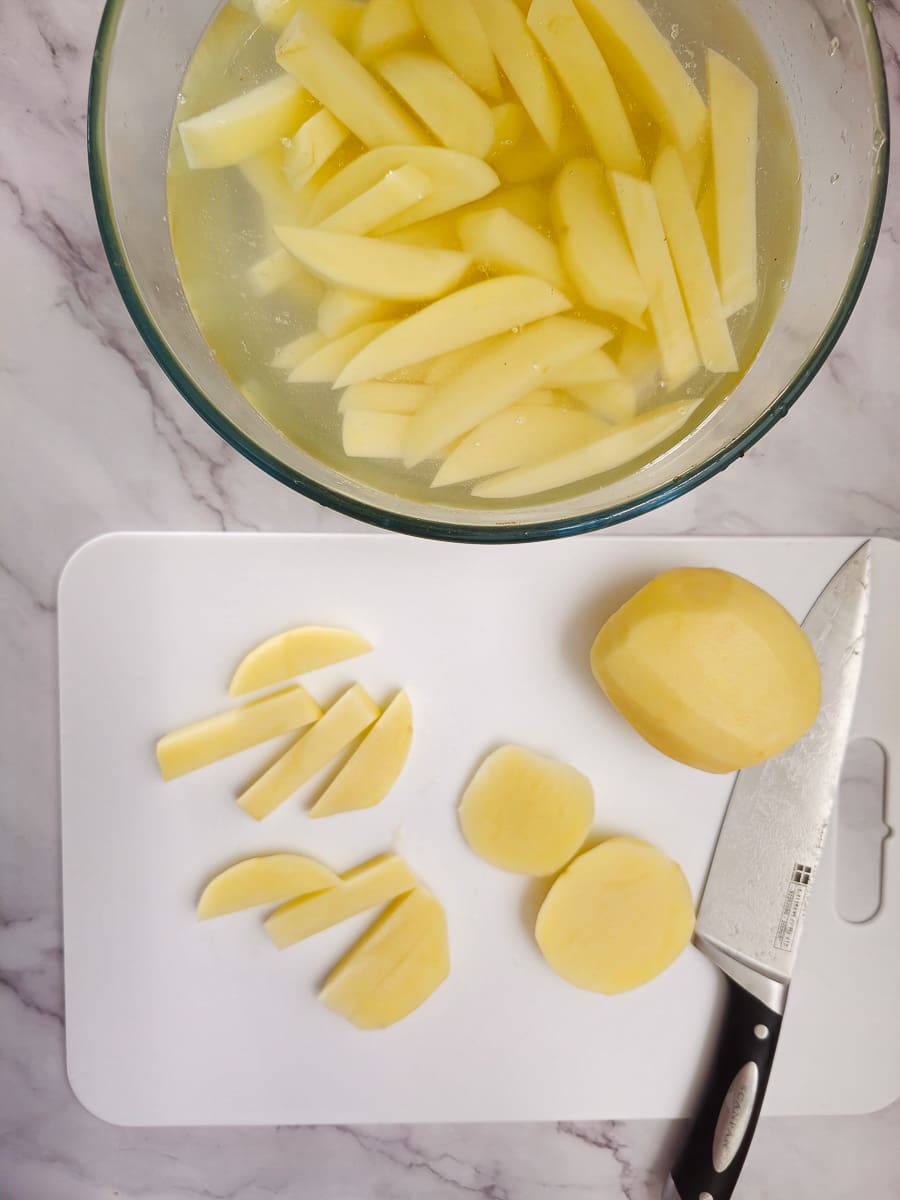 Greek Olive Oil Fries - Patates Tiganites, chopping potatoes on board