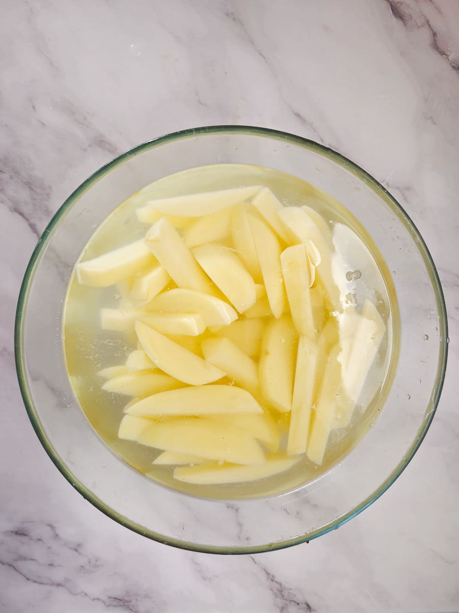 Greek Olive Oil Fries - Patates Tiganites, in bowl with water