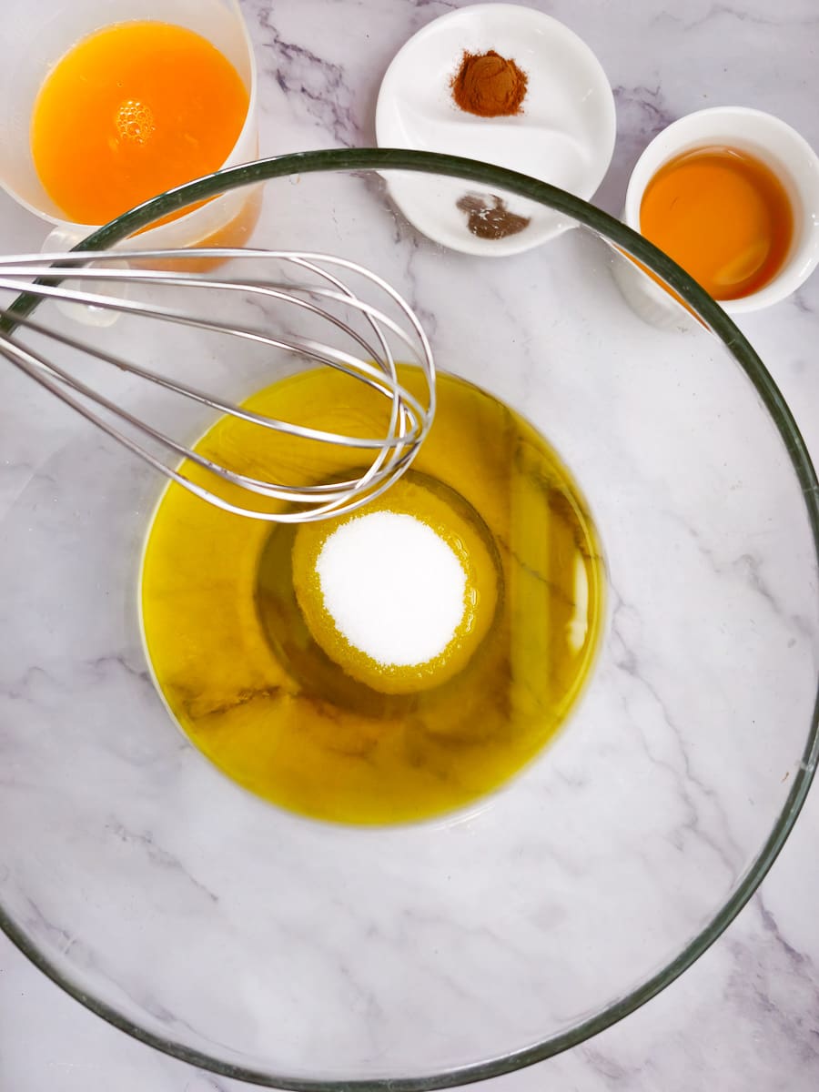 whisking oil and sugar in a bowl