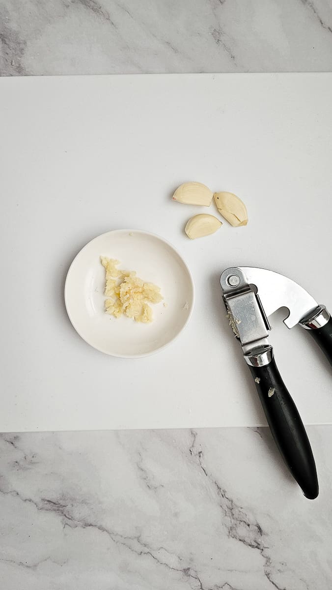 crushed garlic on chopping board