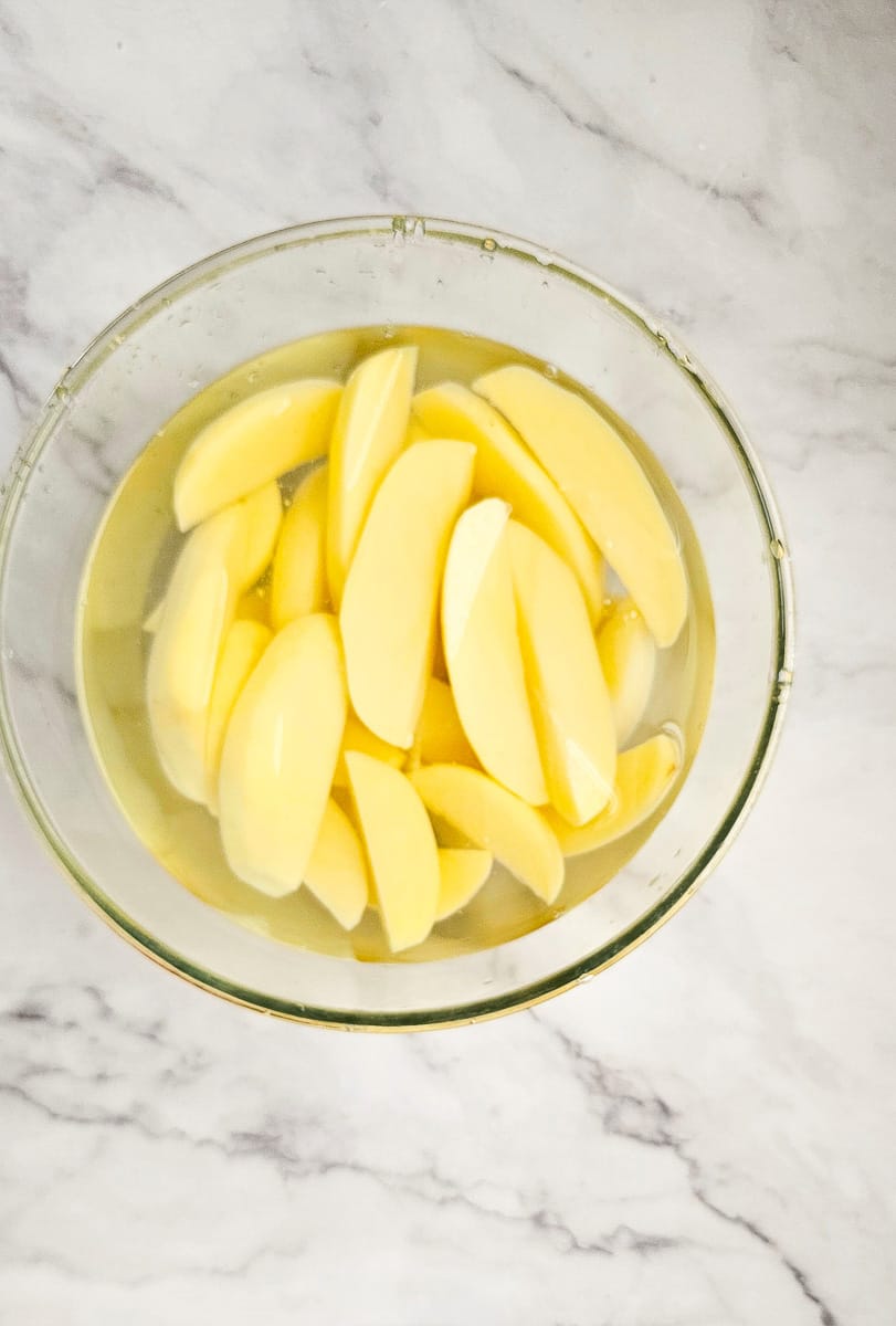 potato wedges in a bowl of water