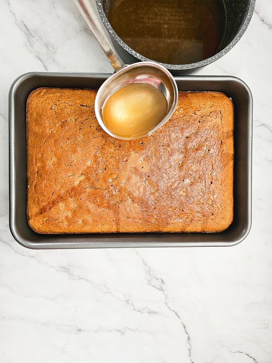 Karidopita - Greek Walnut Cake pourng syrup over cake