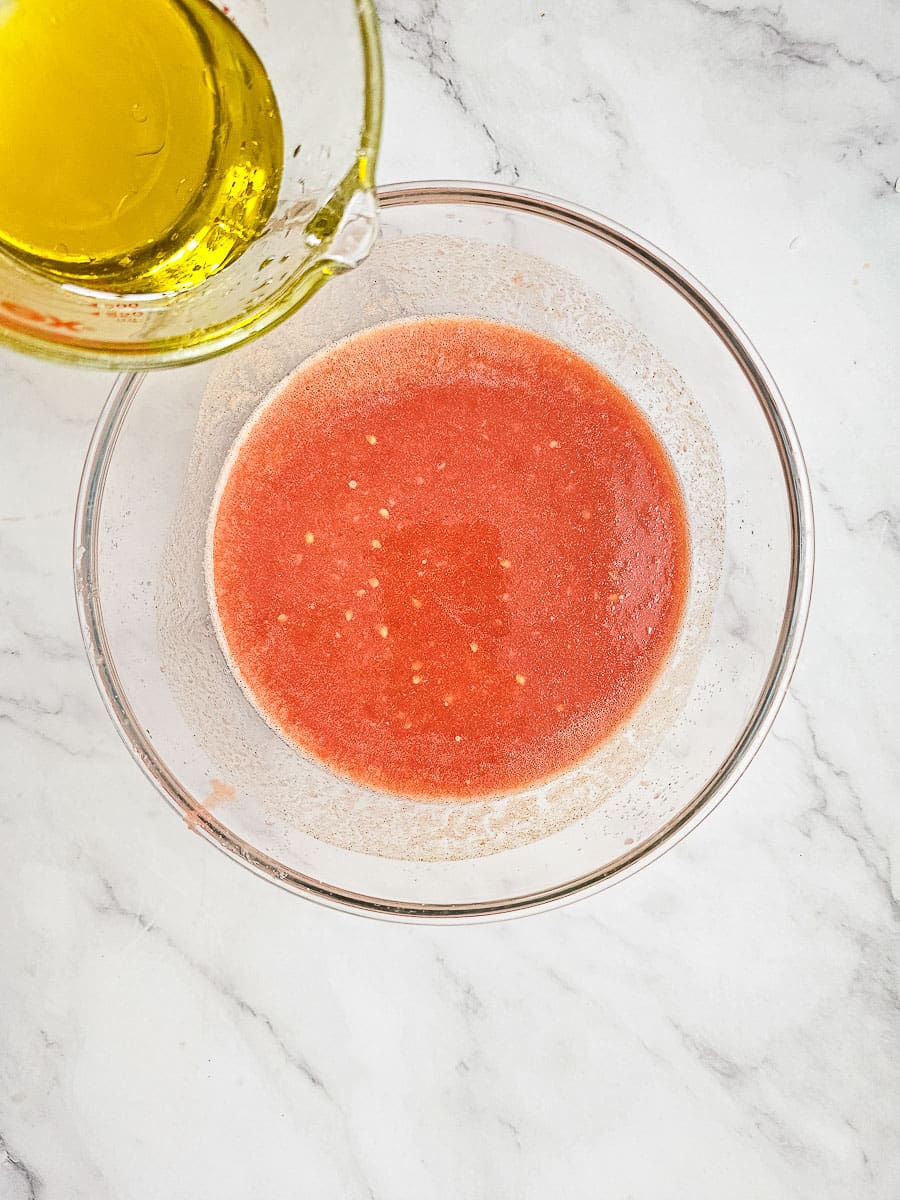 adding oil to tomato sauce for Greek Stuffed Tomatoes with Rice