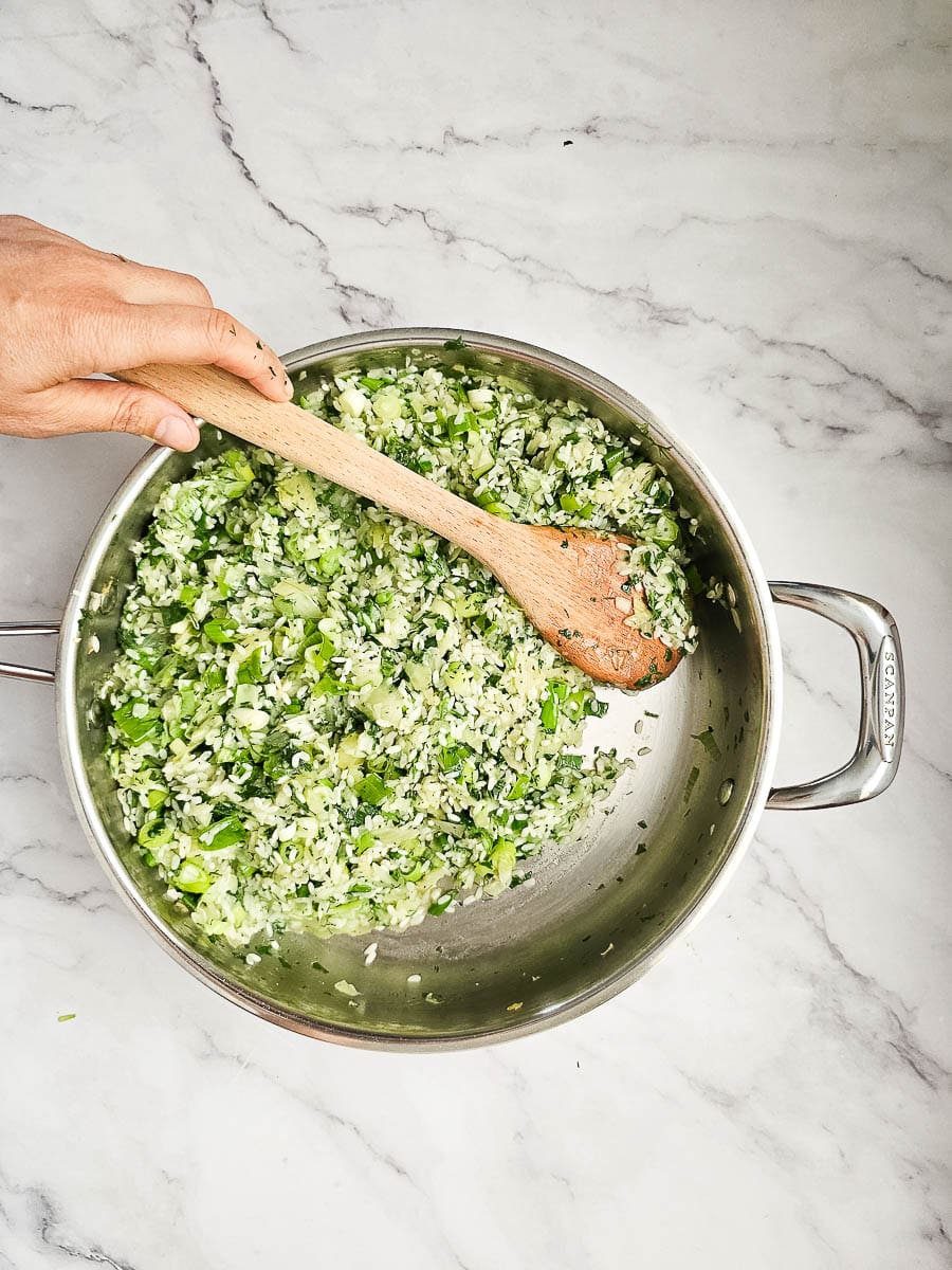 sauteing onions, rice and herbs in saucepan