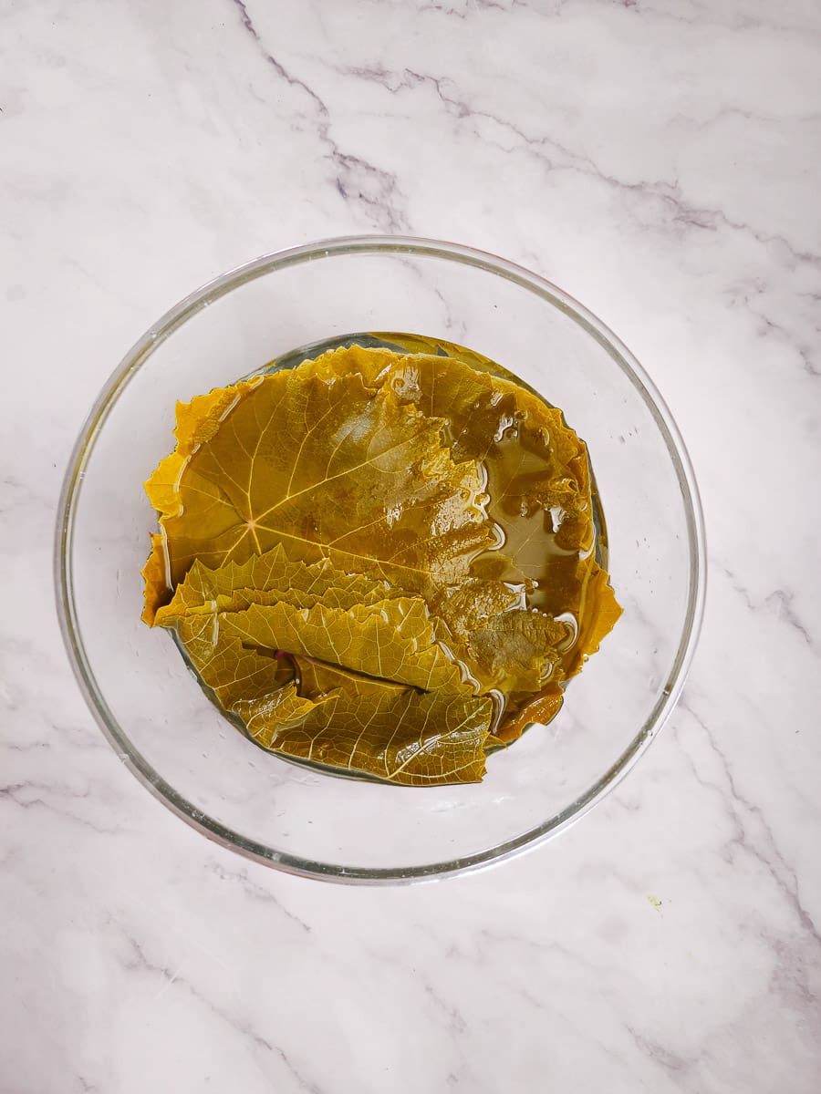 vine leaves in bowl of iced water