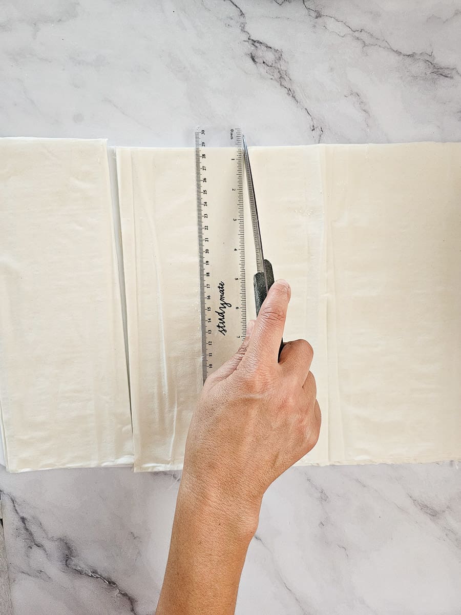cutting filo pastry for Folding Baklava Rolls - Saragli